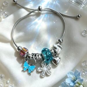 PULSERA PLATEADA CON DIJES DE CORAZON Y FLOR CON PIEDRAS Y PERLA MARIPOSA AZUL GGL-0001